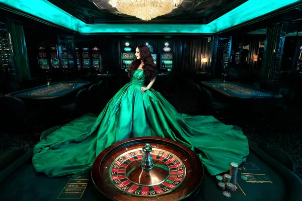 A woman in a luxurious green gown next to an ornate roulette wheel, capturing the upscale casino mood of 333OKK.